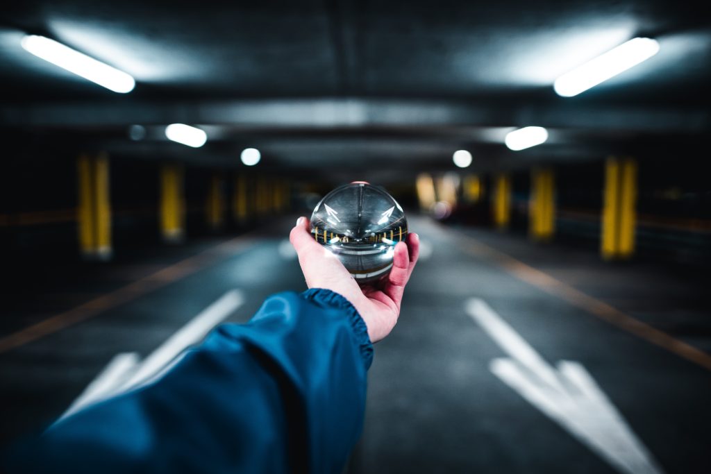 hand holding clear ball that brings into focus the blurred background